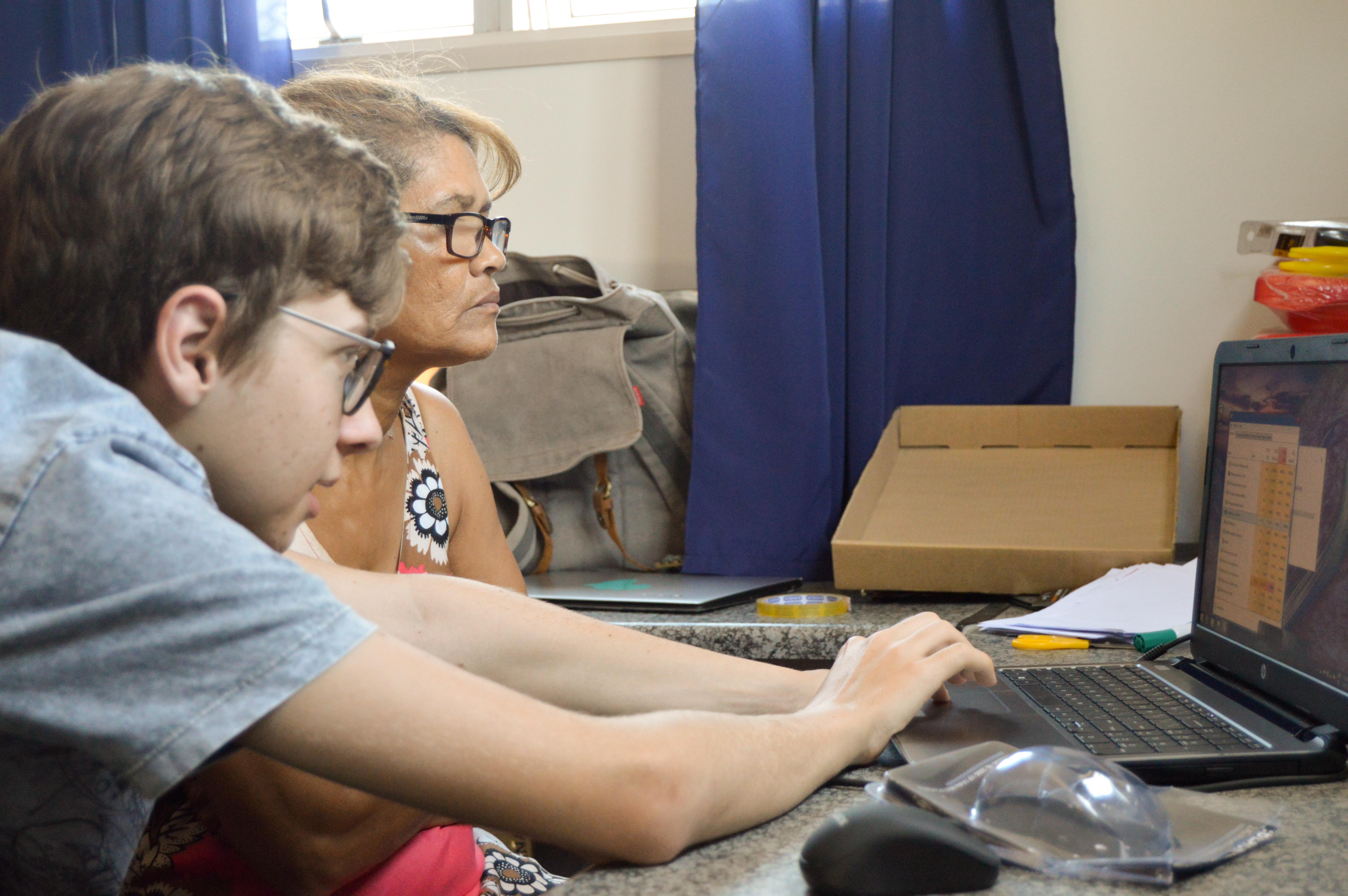 Joven voluntario enseñando informática a una mujer local en Sudáfrica. Una mujer local aprendiendo a utilizar el ordenador con uno de nuestros voluntarios en Sudáfrica.